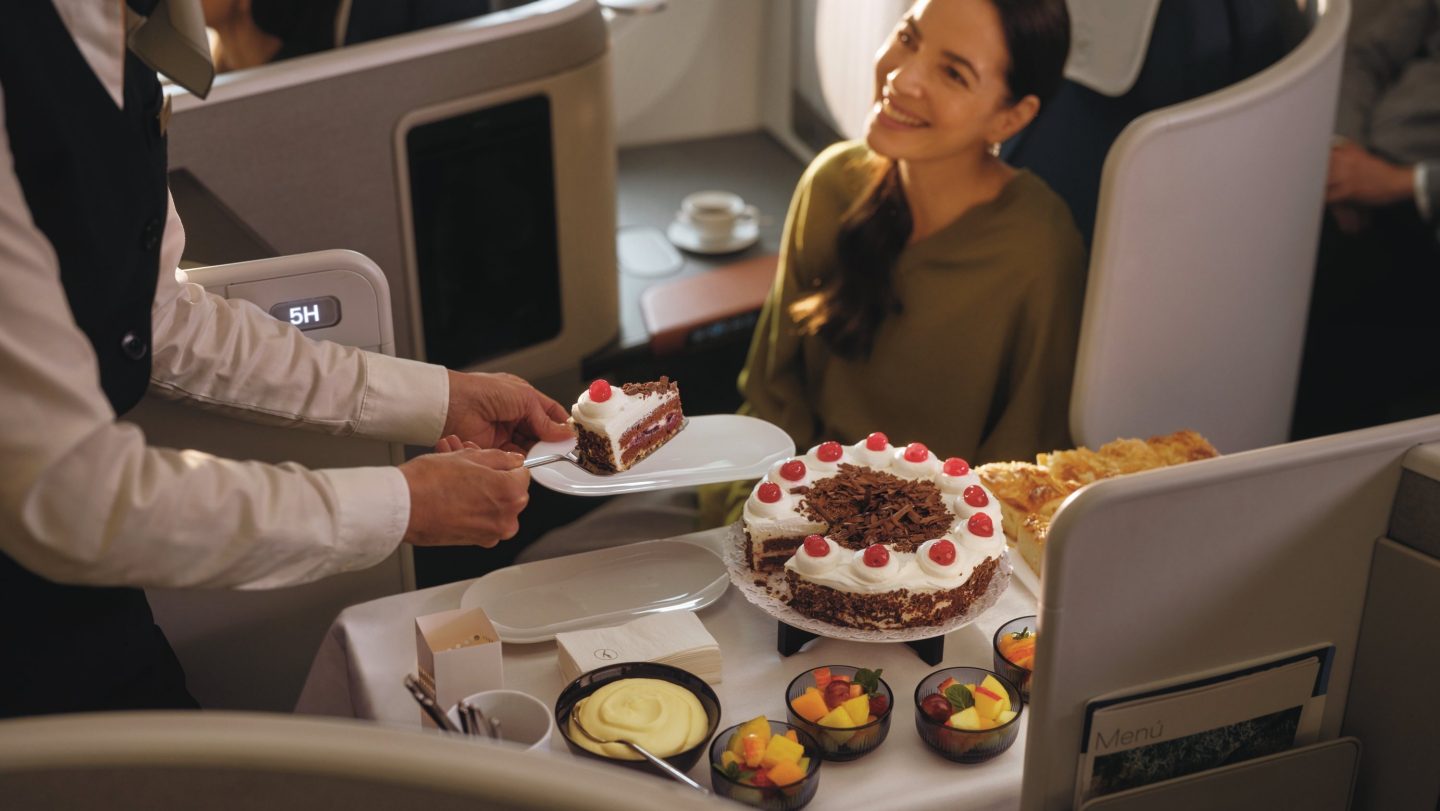Eine Flugbegleitende und eine Passagierin mit dem Kuchenservice in der Lufthansa Allegris Business Class // A flight attendant and a passenger with the cake service in Lufthansa Allegris Business Class