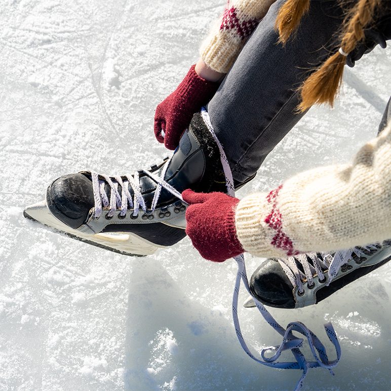 Close-up of a person tying their skates.