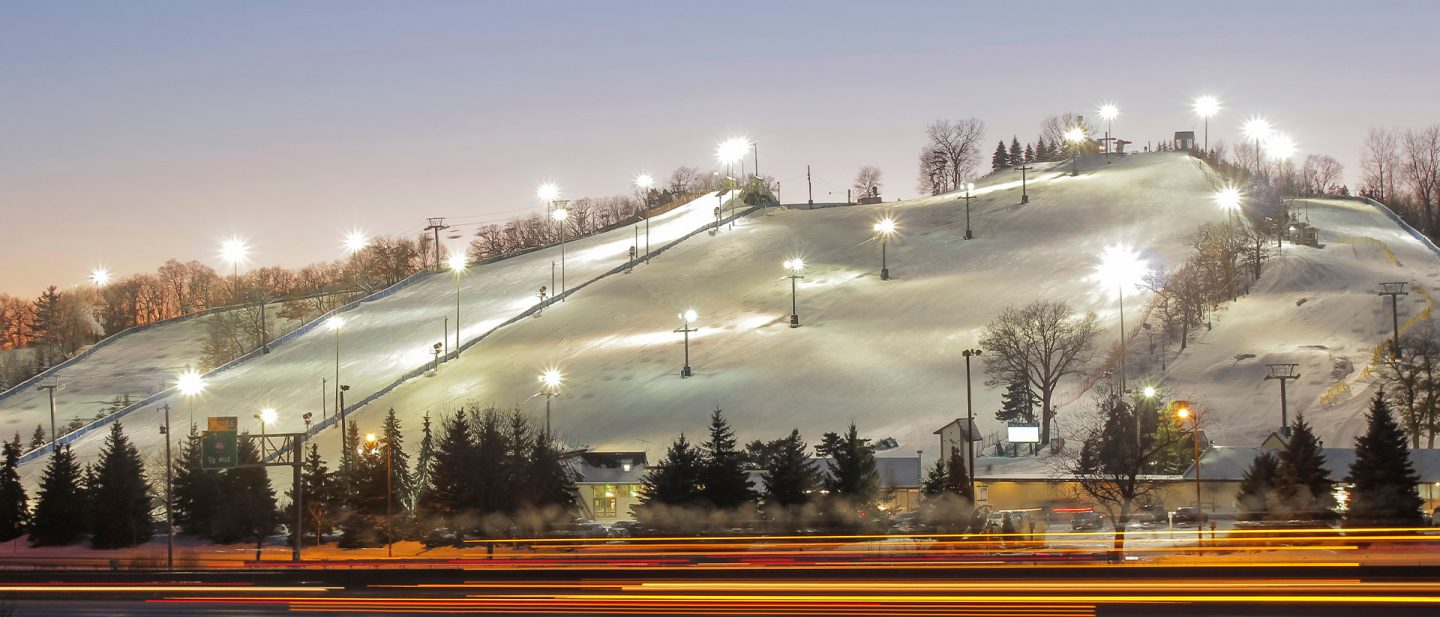 An illuminated ski slope at dusk.