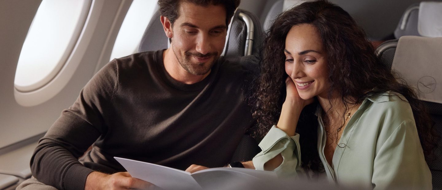 Paar an Bord der Business Class liest Speisekarte. // Couple on board of business class is reading menue.