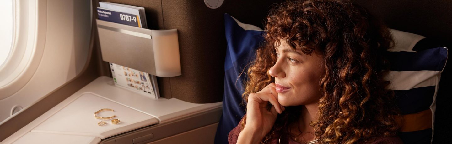 Eine Frau sitzt entspannt in der Business Class. // A woman sits relaxed in business class.