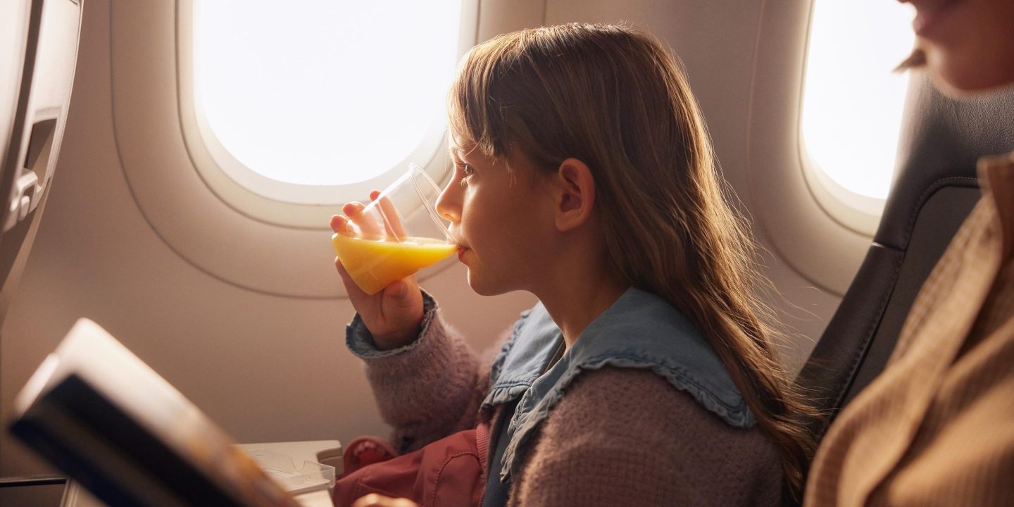 Ein kleines M&auml;dchen trinkt Orangensaft in der Economy Class des A320neo. // A little girl drinks orange juice in Economy Class on the A320neo.