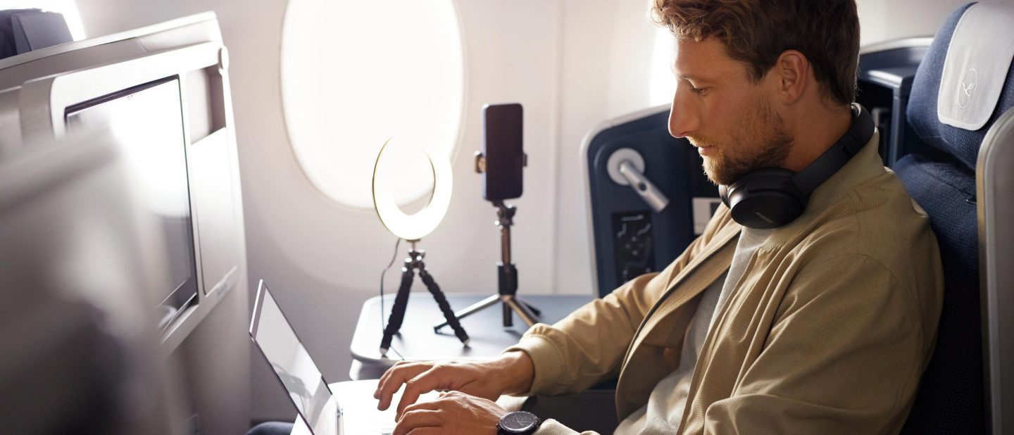 Ein Mann arbeitet in der Business Class an seinem Laptop. // A man works on his laptop in business class.