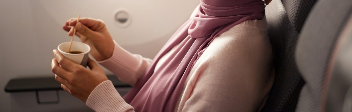 Junge Frau mit Hijab trinkt Kaffee an Bord. // Young woman wearing hijab is drinking coffee on board.