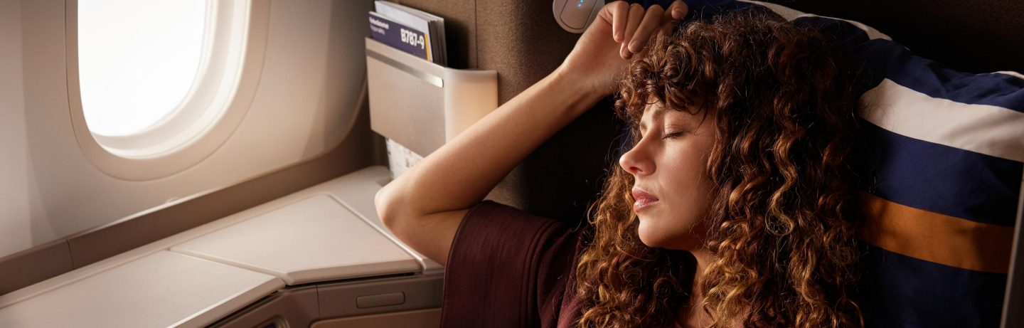 Eine Frau sitzt entspannt in der Business Class. // A woman sits relaxed in business class.