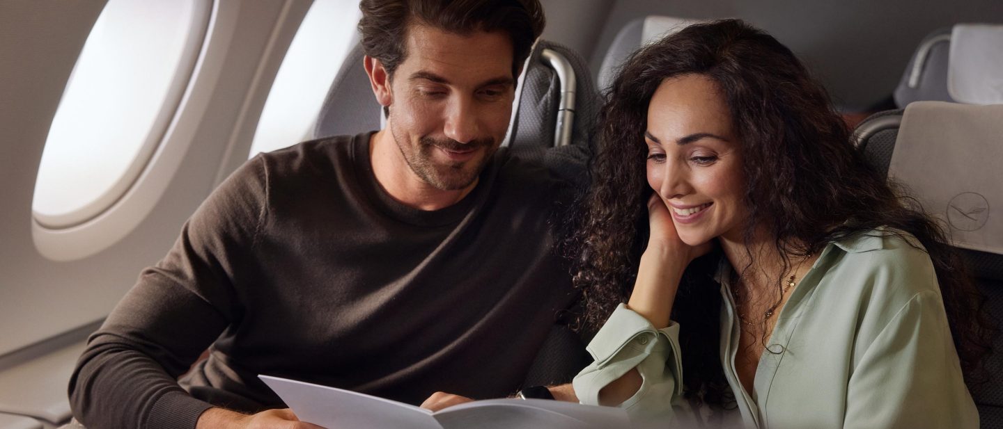 Paar an Bord der Business Class liest Speisekarte. // Couple on board of business class is reading menue.