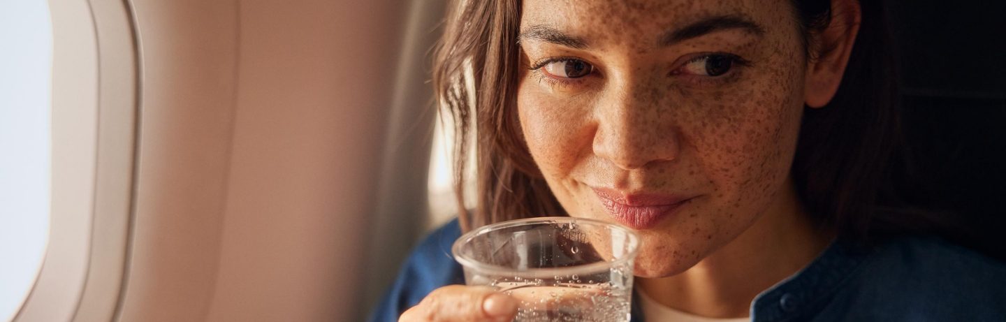 Ein M&auml;dchen mit Sommersprossen reist in der Economy Class des A320neo. Sie trinkt ein Glas Wasser.  // A girl with freckles is traveling in Economy Class on the A320neo. She is drinking a glass of water. 