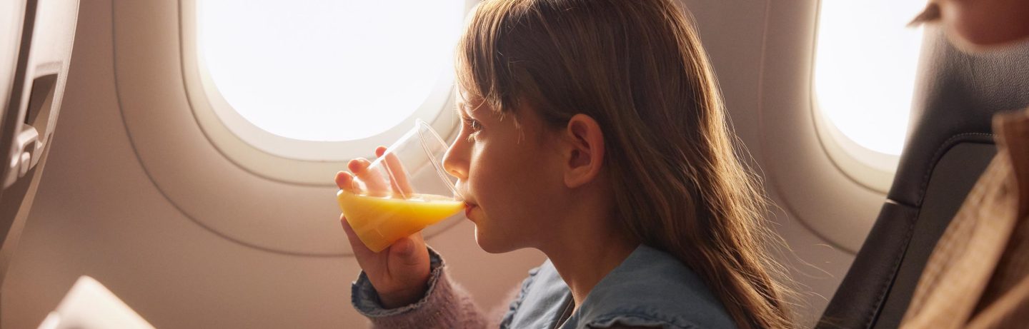 Ein kleines M&auml;dchen trinkt Orangensaft in der Economy Class des A320neo. // A little girl drinks orange juice in Economy Class on the A320neo.