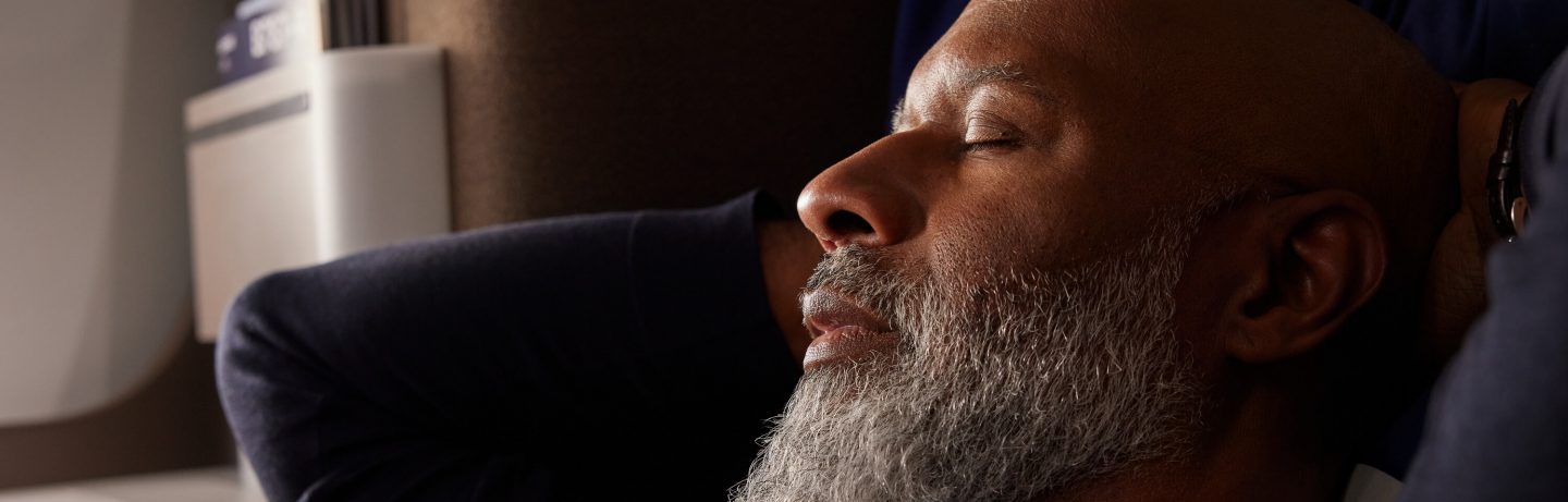 Man on airplane with eyes closed. 